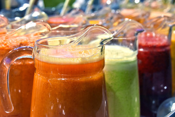 Pitchers with different sorts of fresh vegetable and fruit juice