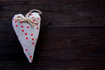 hand made valentine heart with red and white dots on rustic wooden background