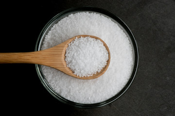 Centered Bowl of Sea Salt on Black with Wooden Spoon Handle to t