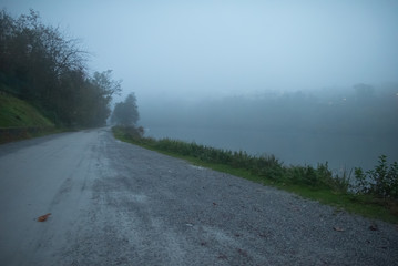 Trail near the bank of a river in the fog