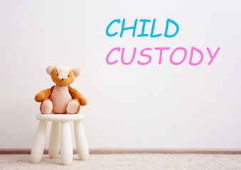 Children stool with toy. Text CHILD CUSTODY on wall background