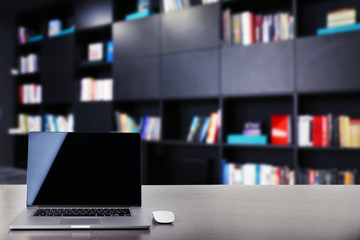 Modern laptop on table at library