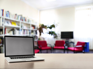 Modern laptop on table at library