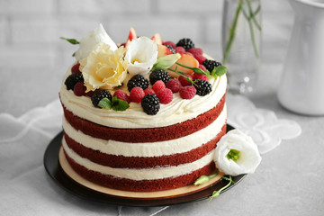Delicious cake with fruit and berries decoration on gray table