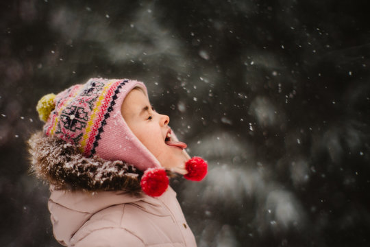 girl catching snow on tongue