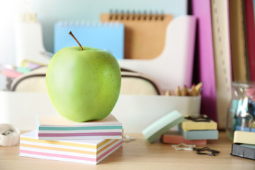 Green apple with colorful stationery