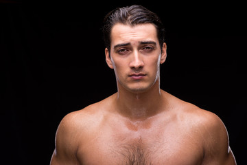 Naklejka premium Ripped muscular handsome man on black background