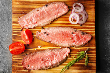 Delicious sliced steak with vegetables on board, closeup