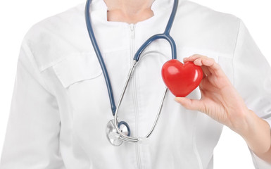 Female doctor with stethoscope holding heart, on white background