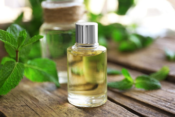 Essential oil with mint on wooden table