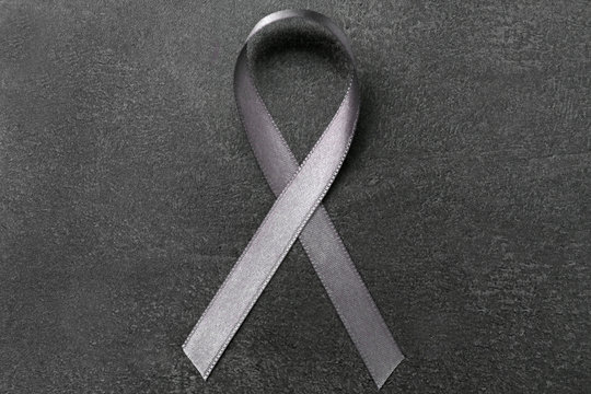 Grey ribbon on dark background. Brain cancer, diabetes, asthma concept