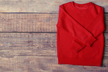 Warm red sweater on wooden background