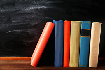 Books on blackboard background © Africa Studio