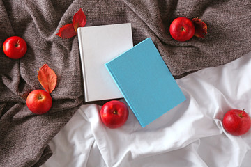 Naklejka na ściany i meble Books with cup of tea and autumn apples on bed