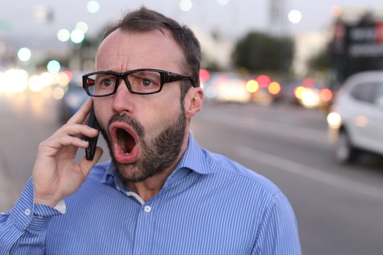 Man screaming in the smart phone.Dramatic portrait style image
