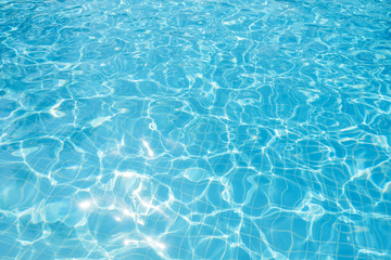 Fototapeta na wymiar Rippled water in swimming pool with sun reflection