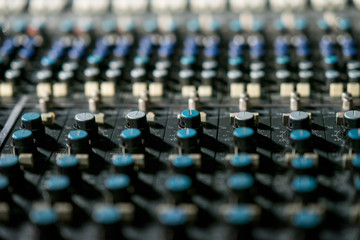Obraz premium Vintage sound or audio mixer in a recording studio. Knobs, dials and sliders on a soundboard.