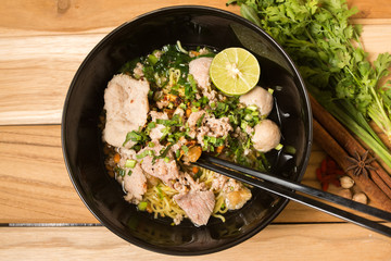 bowl of noodles with vegetables and soft boiled egg on wooden ta