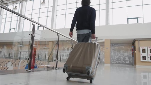 Business man with suitcase in hall of airport, student freelancer travelling