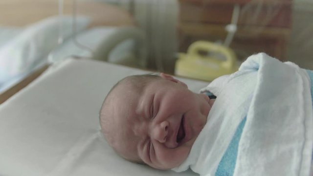 Newborn Baby Sleeping in Hospital Delivery Room Bed Gets Picked Up