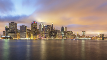 Downtown Manhattan Skyline Lights at Dusk with Clouds