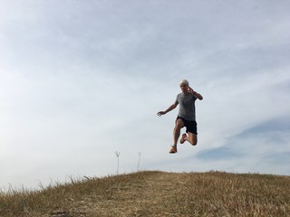 Man running fast downhill on grassy bank