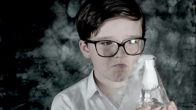 4k Science Shot of a Boy in Laboratory Holding Toxic Liquid with Smoke