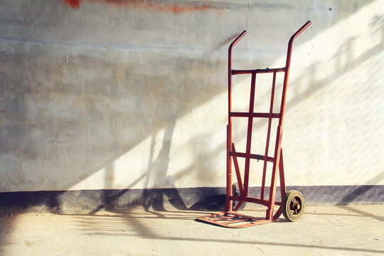 Red empty sack barrow or hand truck dolly  Beside old walls back