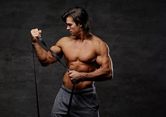 Obraz na płótnie Canvas A man doing biceps workouts with fitness trx straps.