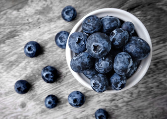 bowl of blueberries on wooden background