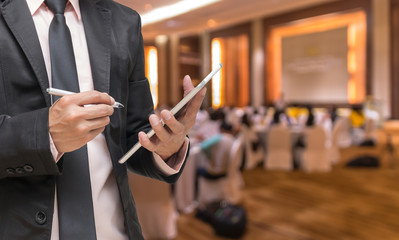 Businessman using the tablet on the Abstract blurred photo of co