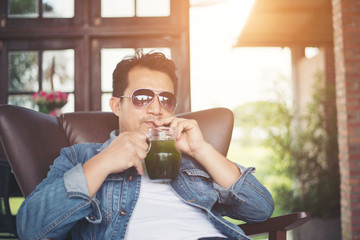 Young man with smartphone smiling relaxing at cafe.