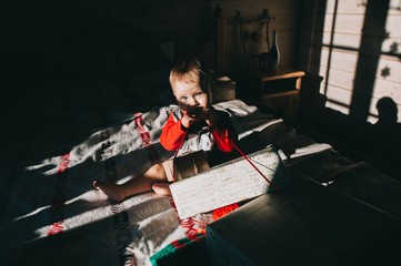 little boy sitting on the bed considering gifts