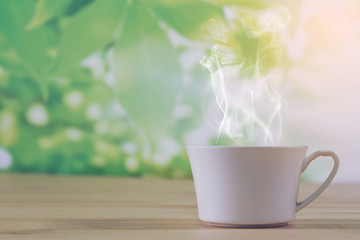 Coffee cup and smoke background green nature bokeh.