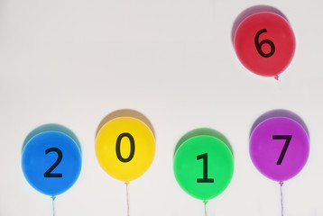Happy New Years 2017 balloons. year changes balloon from 2016 to 2017 on white wall with copy space