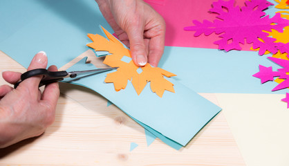 Bastelarbeiten mit Schere und Buntpapier im Winter zur Weihnachtszeit