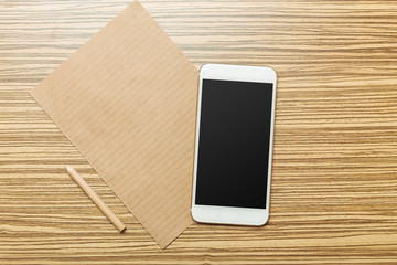 Office table with  smartphone on it. View from above