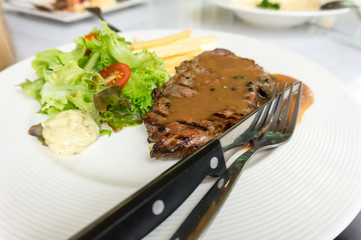 grilled pork steak served with crisp french fries and salad
