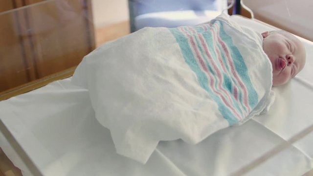 Pan to Adorable Newborn Baby Sleeping in Hospital Bed