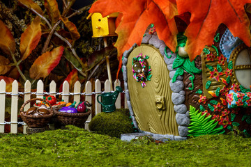 Fairy house in the forest with berries and pumpkins