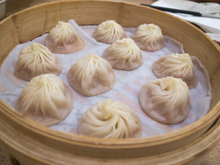 Basket of xiaolongbao (steamed meat bun), famouse asian food. Chinese dumplings on bamboo steamer.