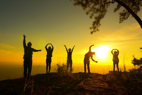 Silhouette of young people against sunset