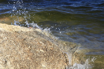 Lake waves break a rock