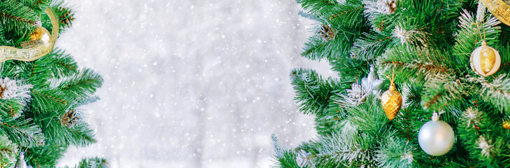 Decorated Christmas tree with bright bokeh on winter snowy background. Christmas border.