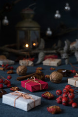 Christmas gifts, rowan, nuts, old lamp on dark surface