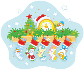 Christmas gift socks with holiday presents hanging over the fireplace, a clock with a Santa hat, a toy decorated tree, fir branches and a small snowman on the mantelshelf