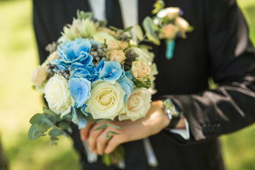 groom holding a modern bouquet