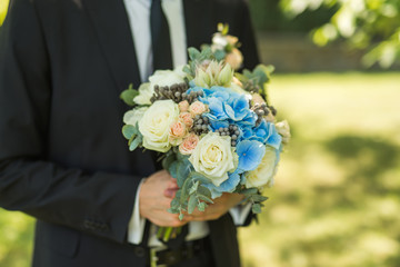 groom holding a modern bouquet