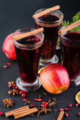 Mulled wine with cinnamon and spices on a dark background