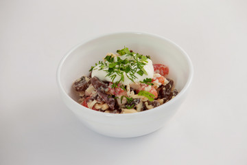 Bowl of salad with tomato, meat, cheese and cream isolated